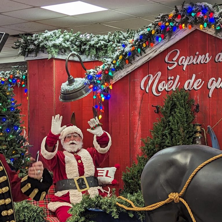 Père Noël posant avec des invités pendant une fête