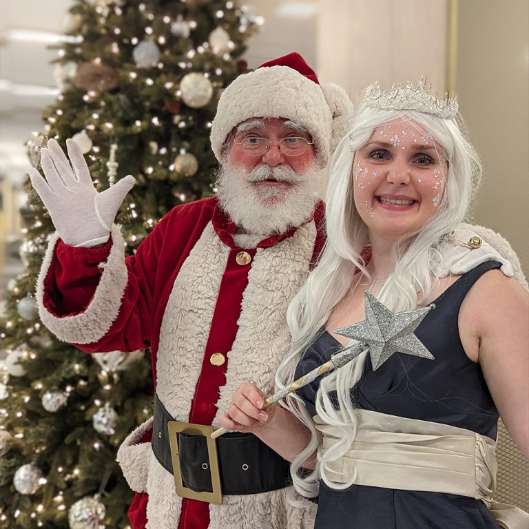 Père Noël professionnel avec une fée lors d'un événement